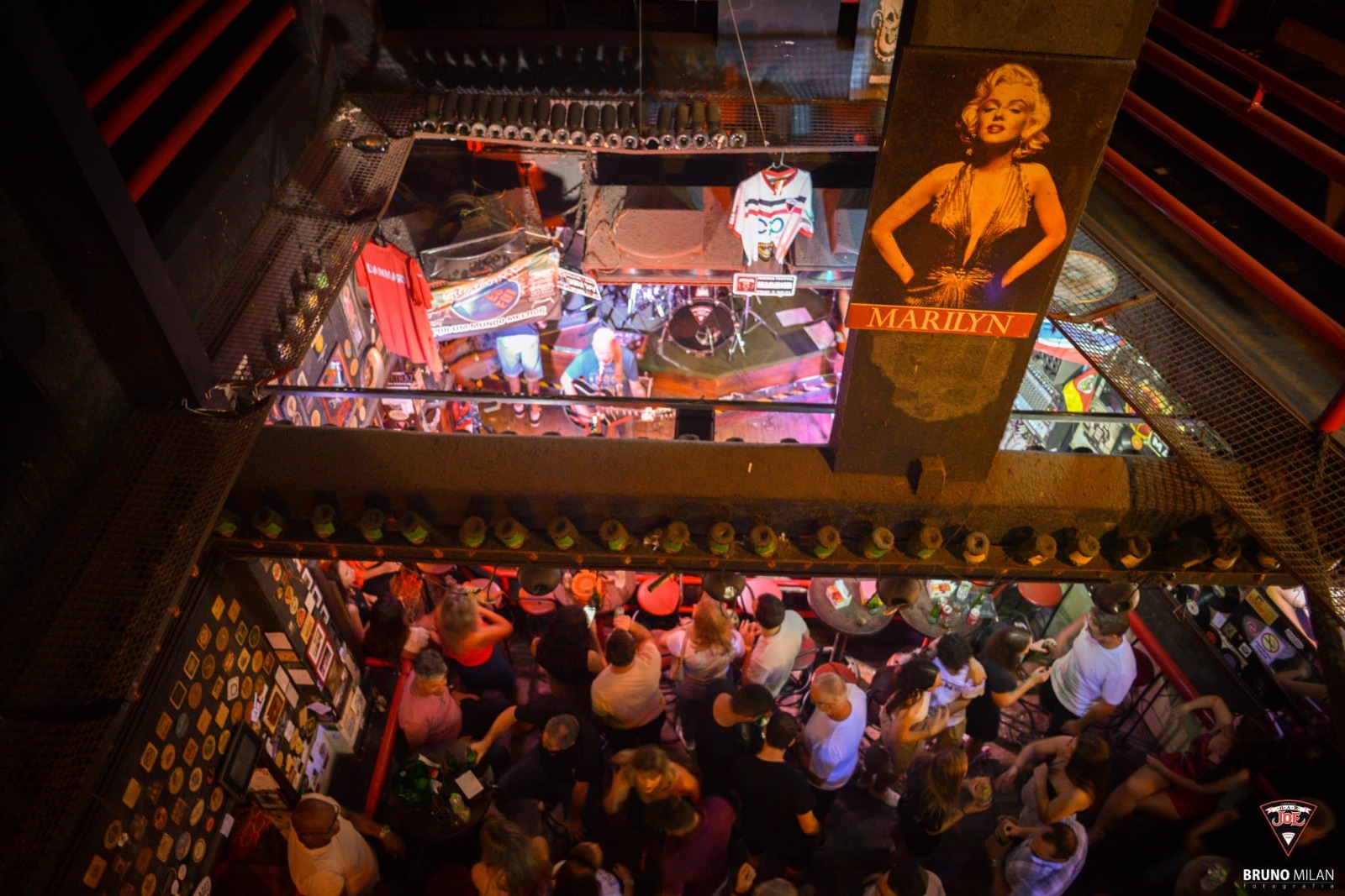 Bar com iluminação vermelha e cartaz da Marilyn Monroe