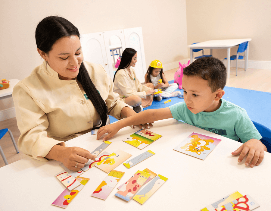 Médica e criança realizando atividade com figuras coloridas