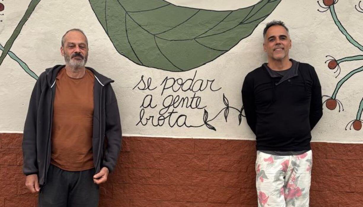 Dois homens em frente a muro desenhado