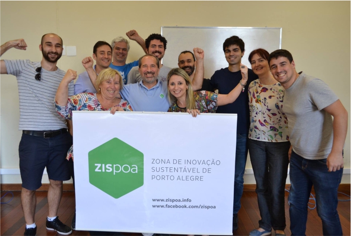 Pessoas segurando cartaz com logo da Zispoa