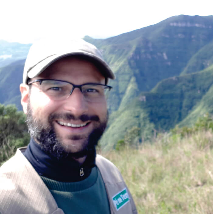 Homem sorrindo com cânions de fundo