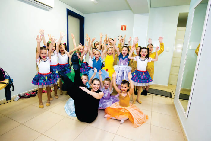 Professora e crianças com roupas de ballet