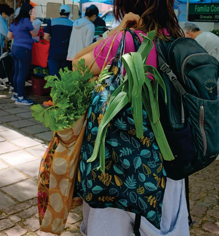 Mulher carregando sacolas de pano