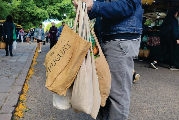 Homem carregando sacolas de pano