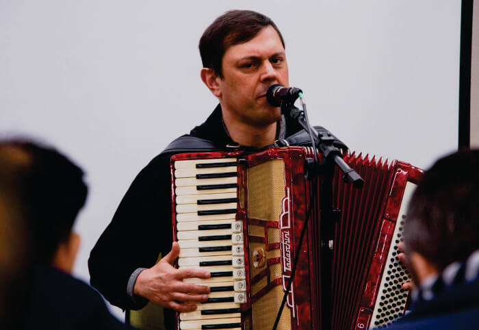 Homem tocando gaita e cantando