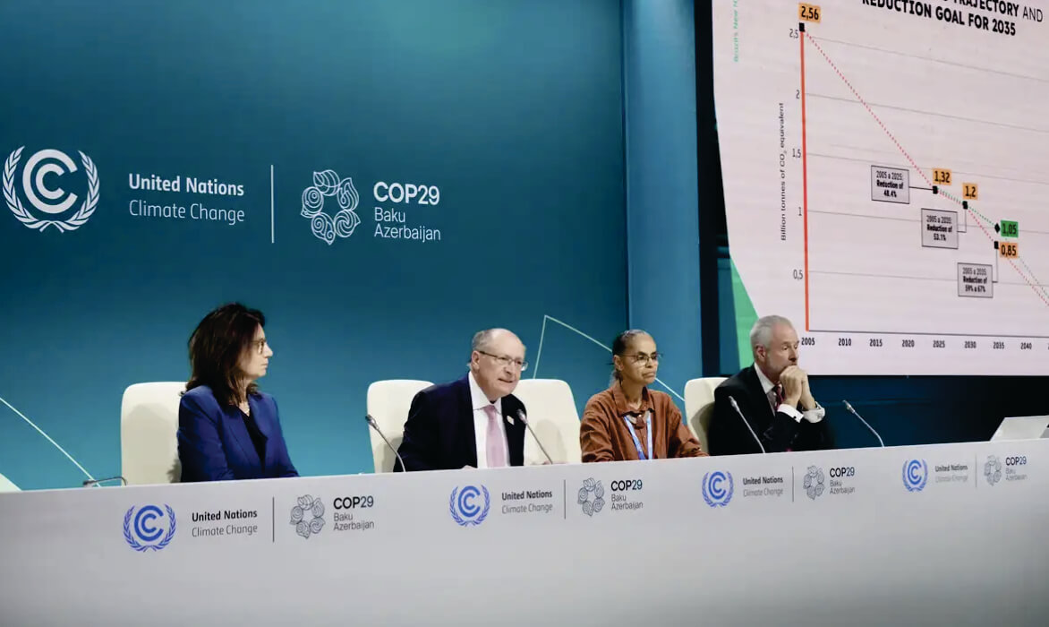 Pessoas sentadas atrás de mesa na COP 29