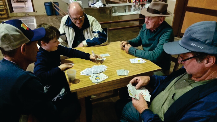 Homens e criança jogando cartas