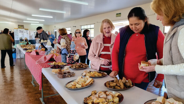 Pessoas servindo-se em mesa com salgados