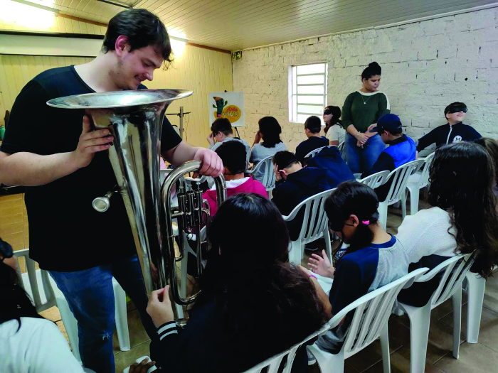 Alunos vendados tocando tuba