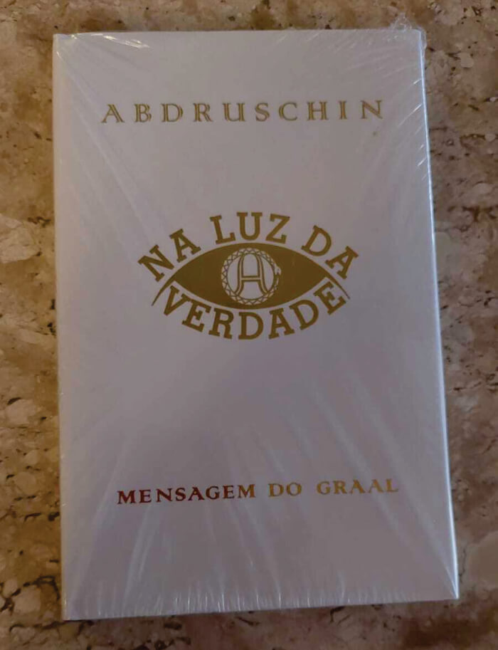 Livro com capa branca e título em dourado