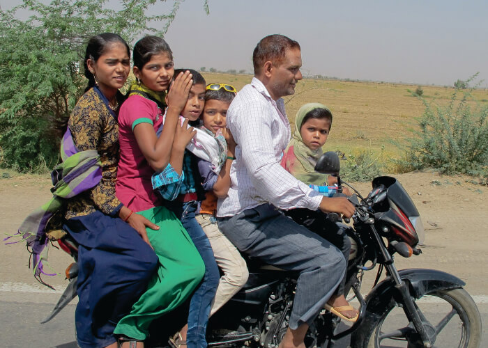 Várias pessoas indianas em cima de moto