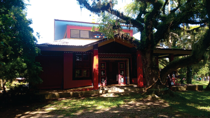 Templo budista vermelho com árvores ao redor
