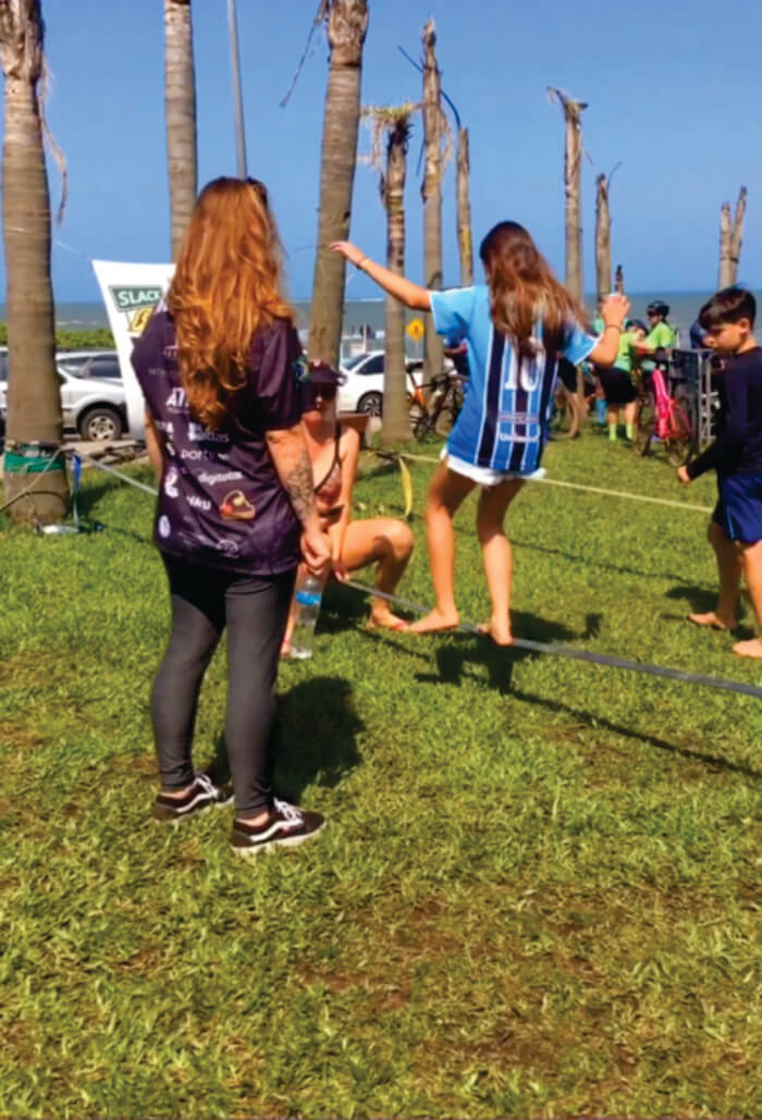 Menina praticando slackline